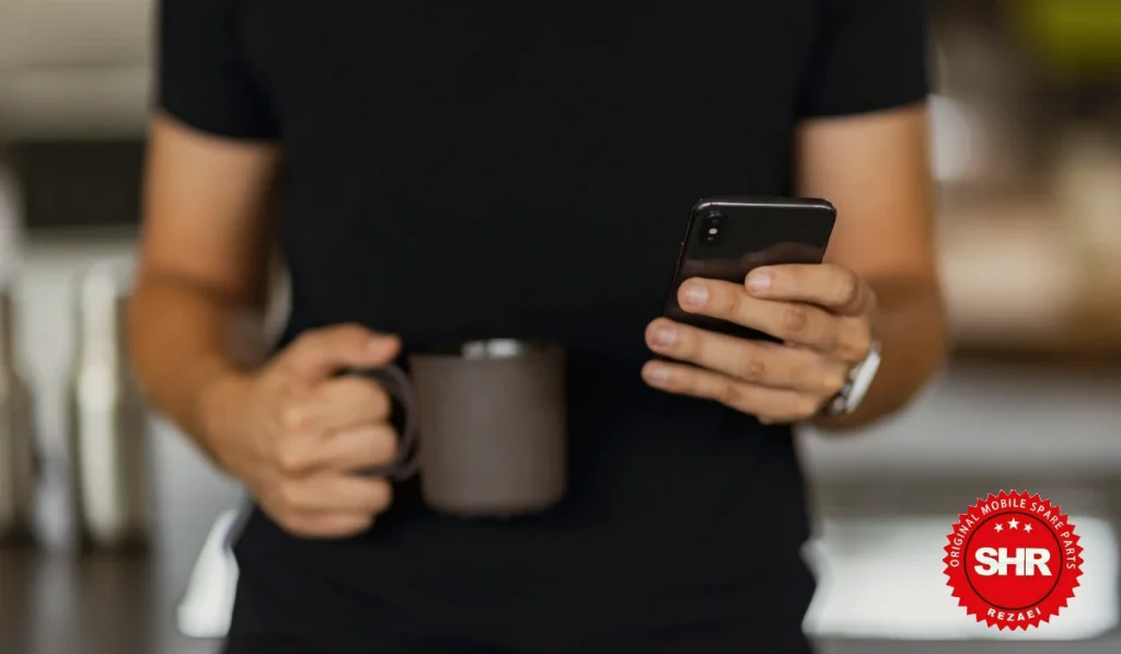 گوشی هوشمند با صفحه کاملاً سیاه و دست کاربر در حال لمس آن